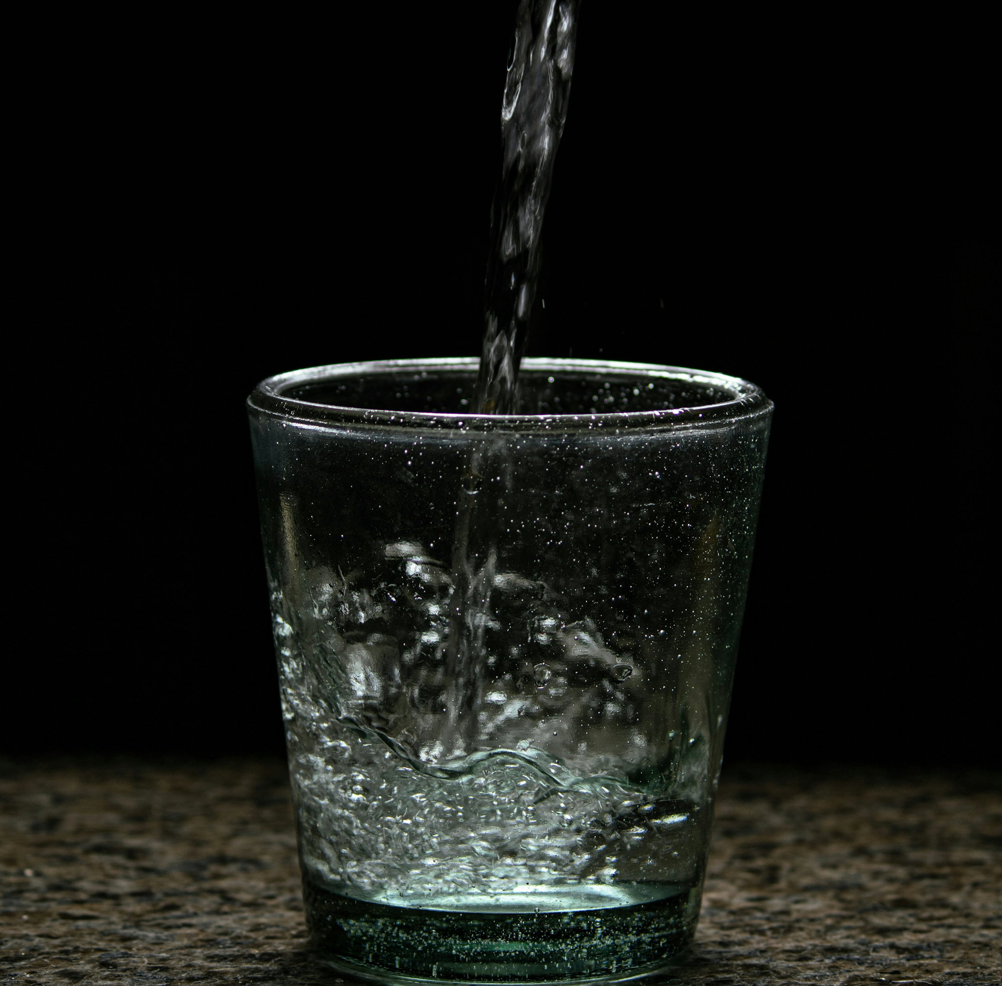 a-glass-of-water-with-a-black-background.jpg a glass of water with a black background